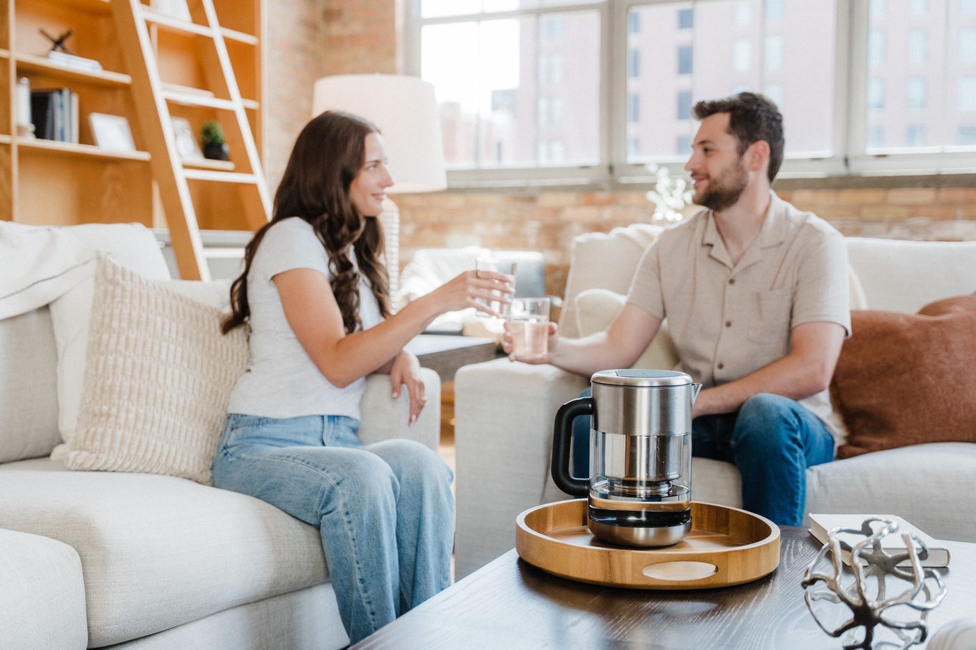 Couple on a sofa with Rorra Pitcher glasses of water in a bright loft