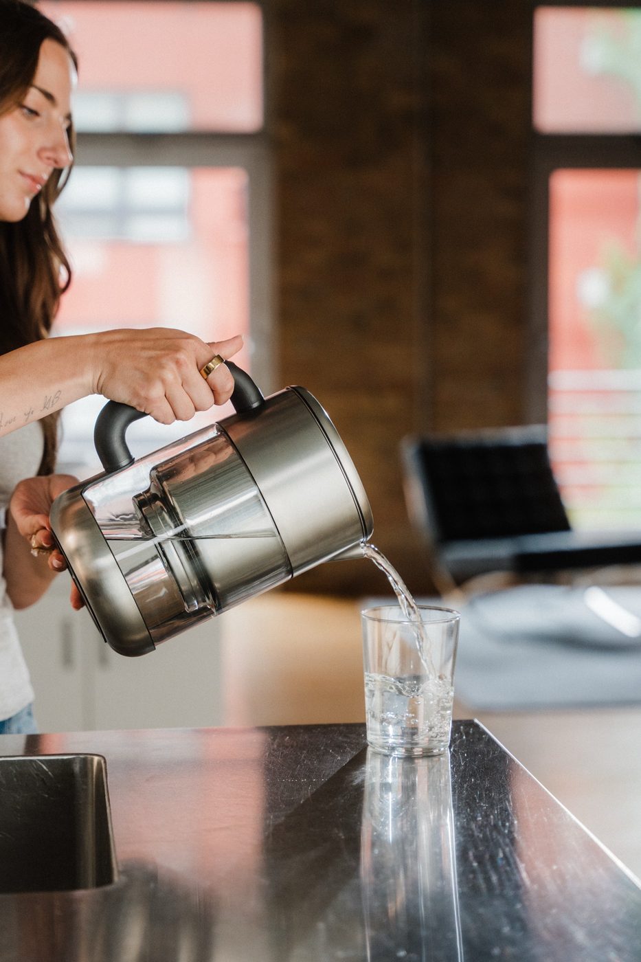 Hands pouring from a Rorra Pitcher into a clear glass