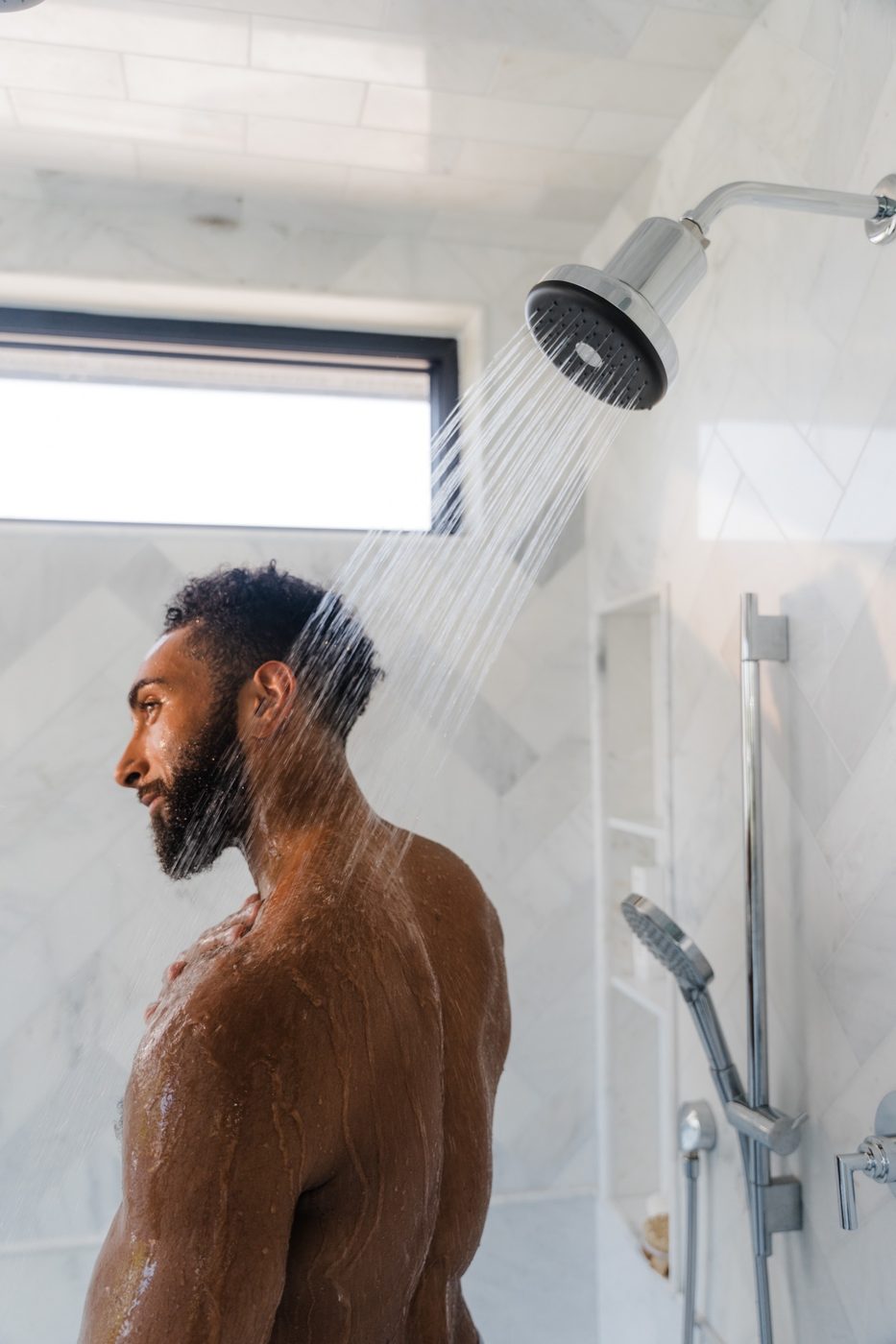 Close profile of a woman under Rorra Showerhead water
